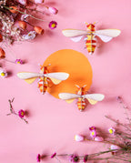 Die Honig Bienen Wanddekoration an einer pinken Wand mit Blumen und einem gelben Punkt