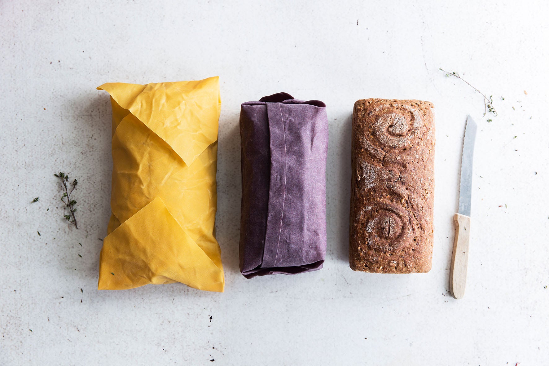 Brot, dass im Gelben Bienenwachstuch eingewickelt ist mit einem Brotmesser 