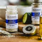 Ein Fläschchen "Krass Tzatziki" Wildkräutermischung von Deligreece geöffnet und gehäuft auf einem Teelöffel