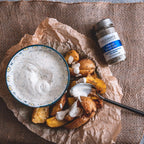 Ein Fläschchen "Krass Tzatziki" Wildkräutermischung von Deligreece neben einer Schüssel Tzatziki gewürzt mit der Mischung und Kartoffelecken