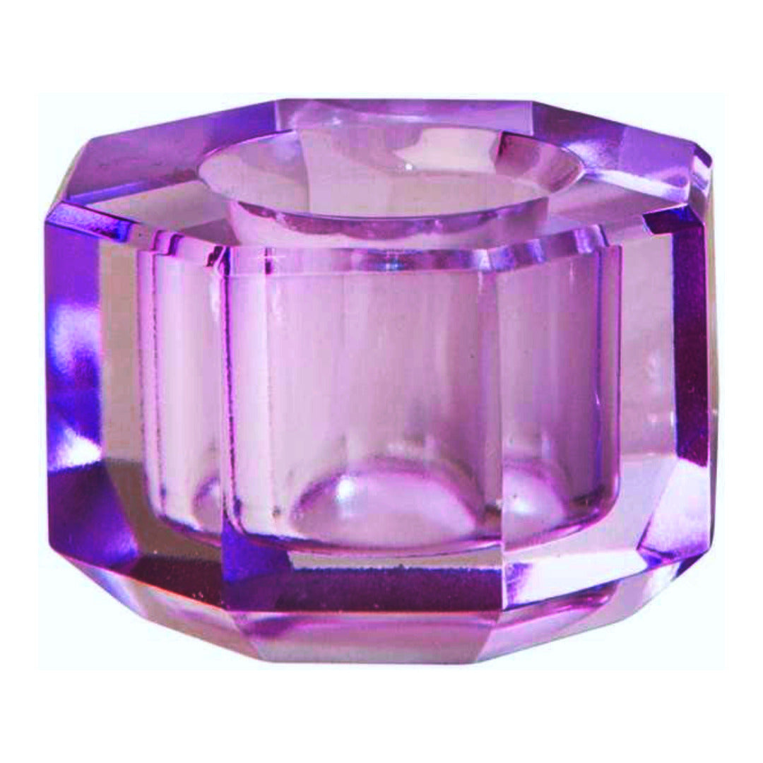 Ein kleiner Kerzenhalter aus Glas in Violett Kristall-Optik, bestehend aus mehreren geometrischen Flächen. Der Kerzenhalter hat eine moderne, facettierte Optik, die das Licht reflektiert