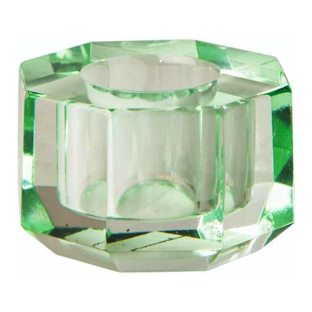 Ein kleiner Kerzenhalter aus Glas in Hellminze Kristall-Optik, bestehend aus mehreren geometrischen Flächen. Der Kerzenhalter hat eine moderne, facettierte Optik, die das Licht reflektiert