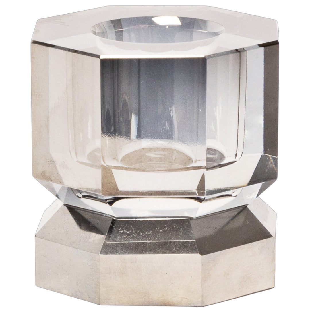 Ein Kerzenhalter in Klarer Kristall-Optik, bestehend aus mehreren geometrischen Flächen. Der Kerzenhalter hat eine moderne, facettierte Optik, die das Licht reflektiert.