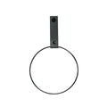 Handtuchhalter in schwarzer Ring Form an der Wand befestigt mit einem dunkel grauen Lederriemen
